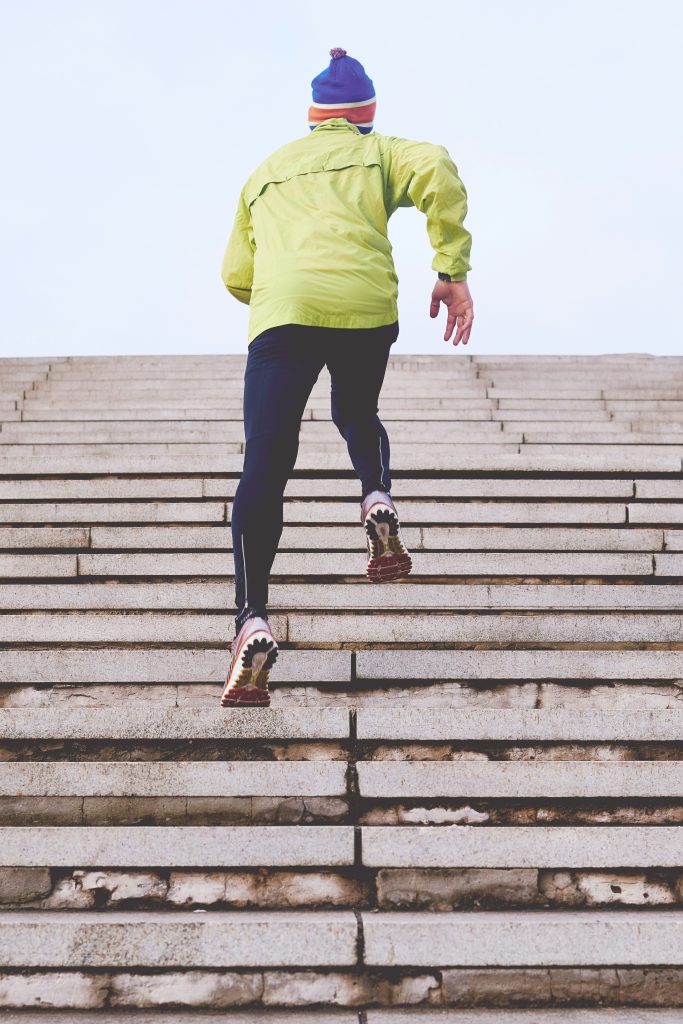 Sportende man die trappen oprent. Afslankmedicatie en samenwerking met BMI Clinic.
