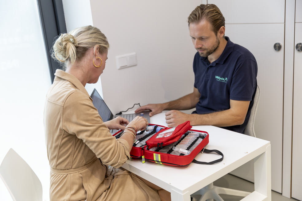 Uitleg over vernieuwde noodtas binnen cosmetische kliniek.